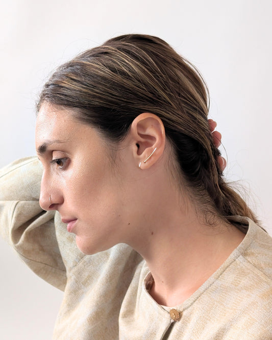 A woman in profile wearing a delicate 14KGF gold hoop earring, shown against a plain light background.