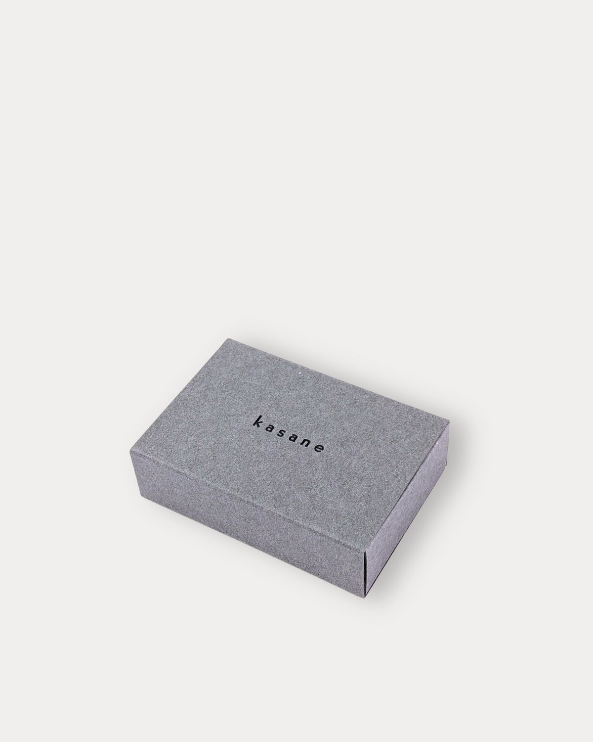 Silver-coloured carton jewellery box with a visible brand logo on a white background