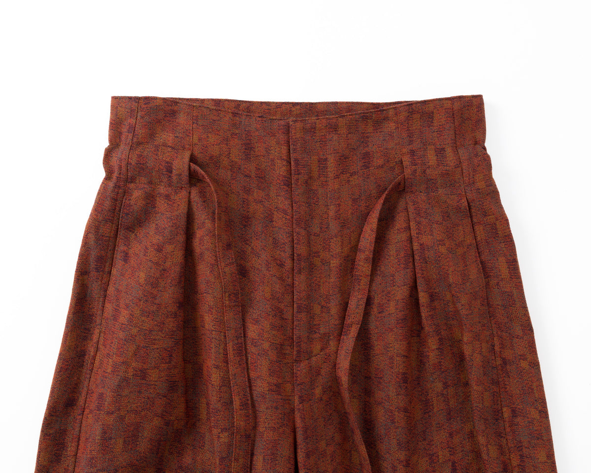 Red patterned trousers on a white background
