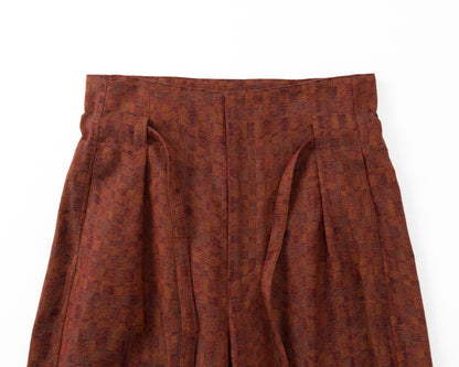 Red patterned trousers on a white background