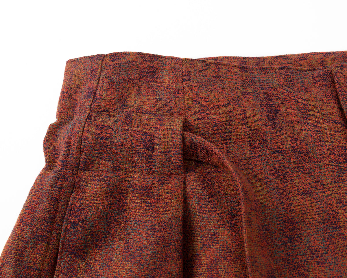 Close-up of a red textured fabric with pleats on a white background