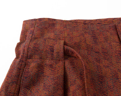 Close-up of a red textured fabric with pleats on a white background