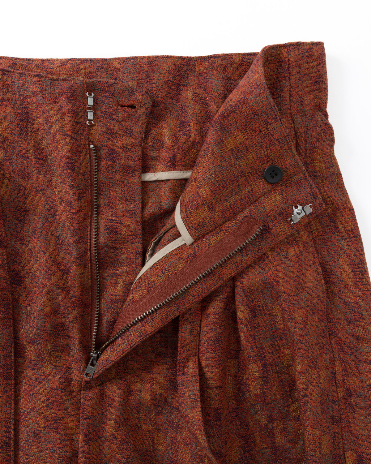 Red textured fabric with zipper and buttons on a white background