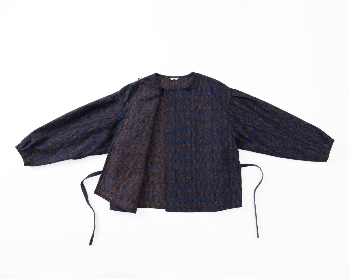 Dark patterned shirt with long sleeves on a white background