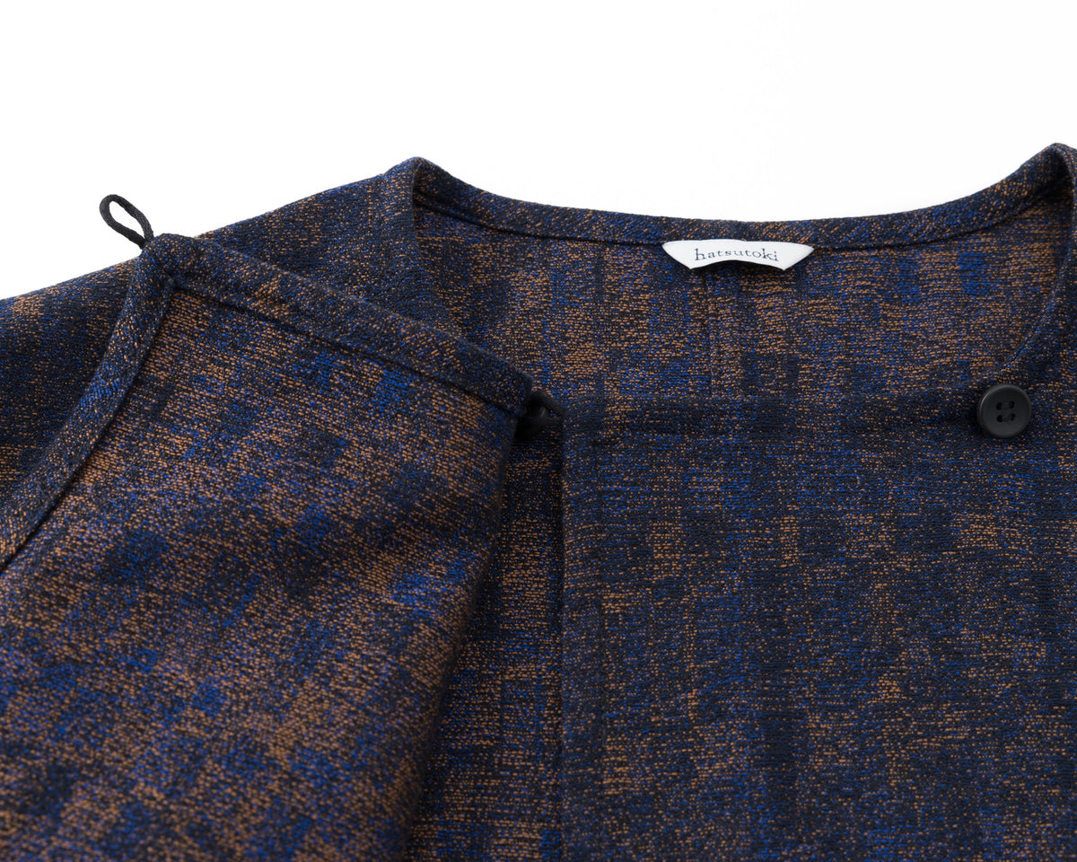 Close-up of a navy and brown patterned garment with a brand label on a white background