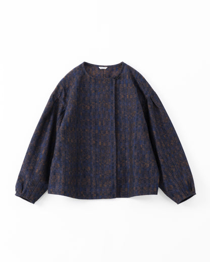 A dark navy blue cropped jacket with a subtle brown and gold abstract pattern, shown against a light grey background.