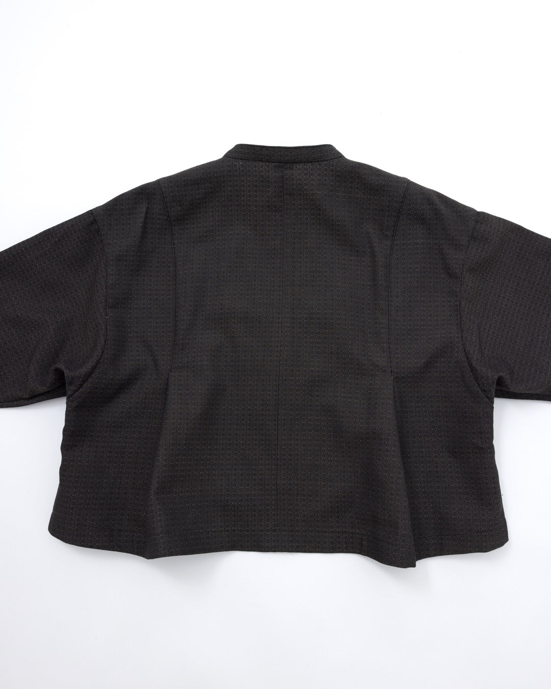 A black cropped jacket with a subtle textured pattern, shown from the back on a plain white background.