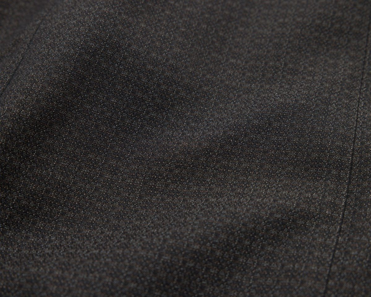 A close-up of black textured fabric with soft folds and a fine woven pattern.