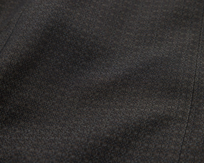 A close-up of black textured fabric with soft folds and a fine woven pattern.