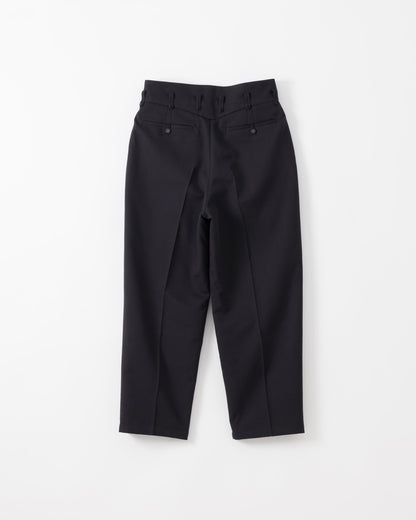 Black tailored trousers with a high waist, front pleats, and button details on the back waistband, shown flat against a light gray background.