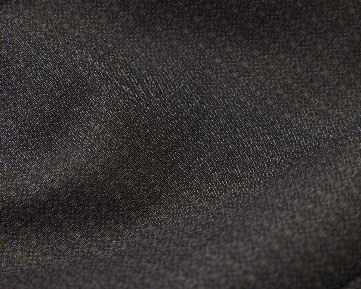 A close-up of black textured fabric with a fine woven pattern and soft folds.