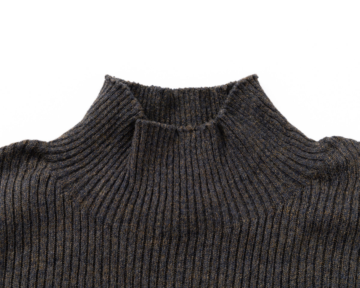 Close-up of a black ribbed knit turtleneck sweater on a plain white background.