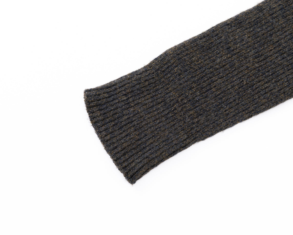 A close-up of a black ribbed knit sleeve cuff on a plain white background.