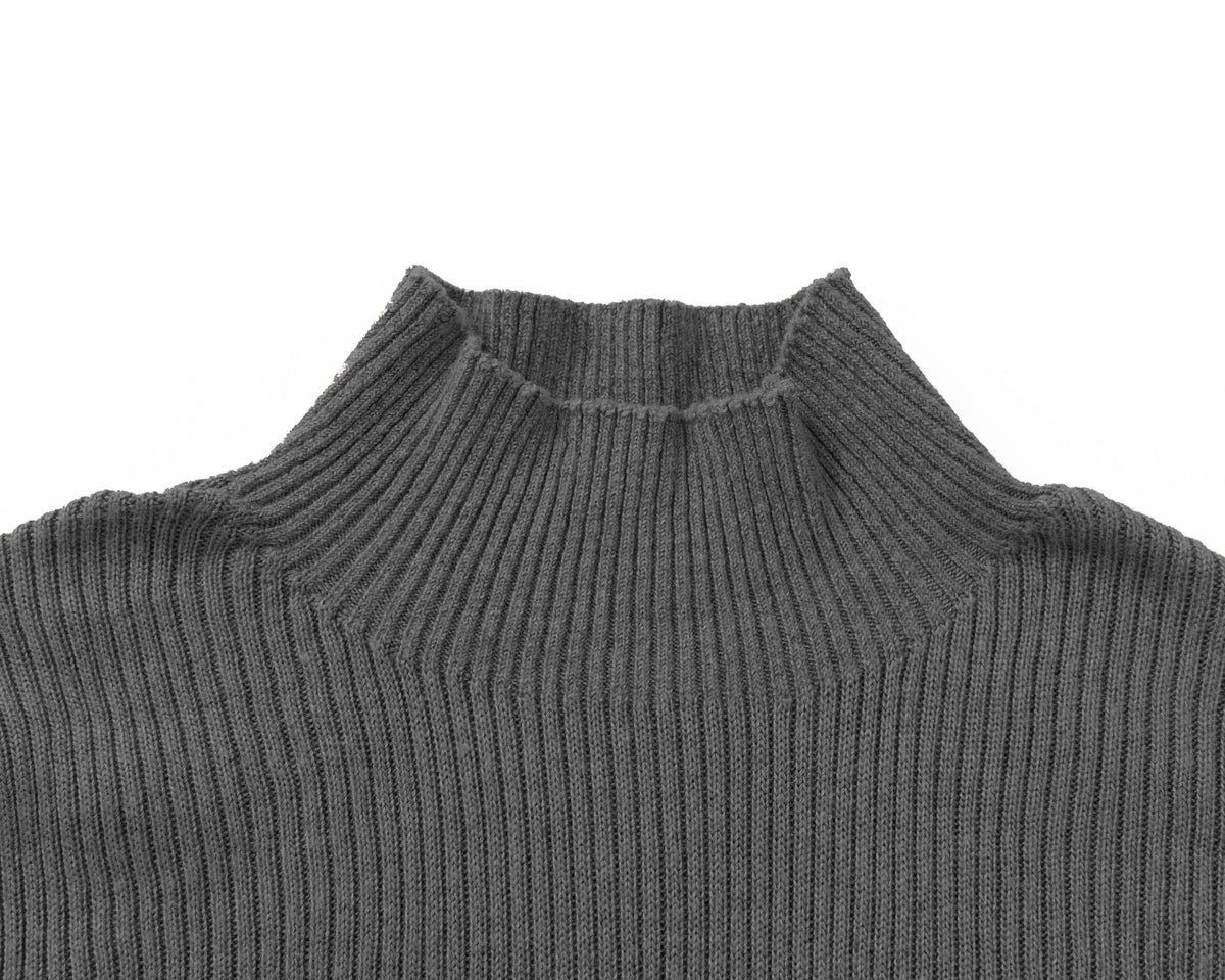 Close-up of a grey ribbed knit turtleneck sweater on a plain white background.