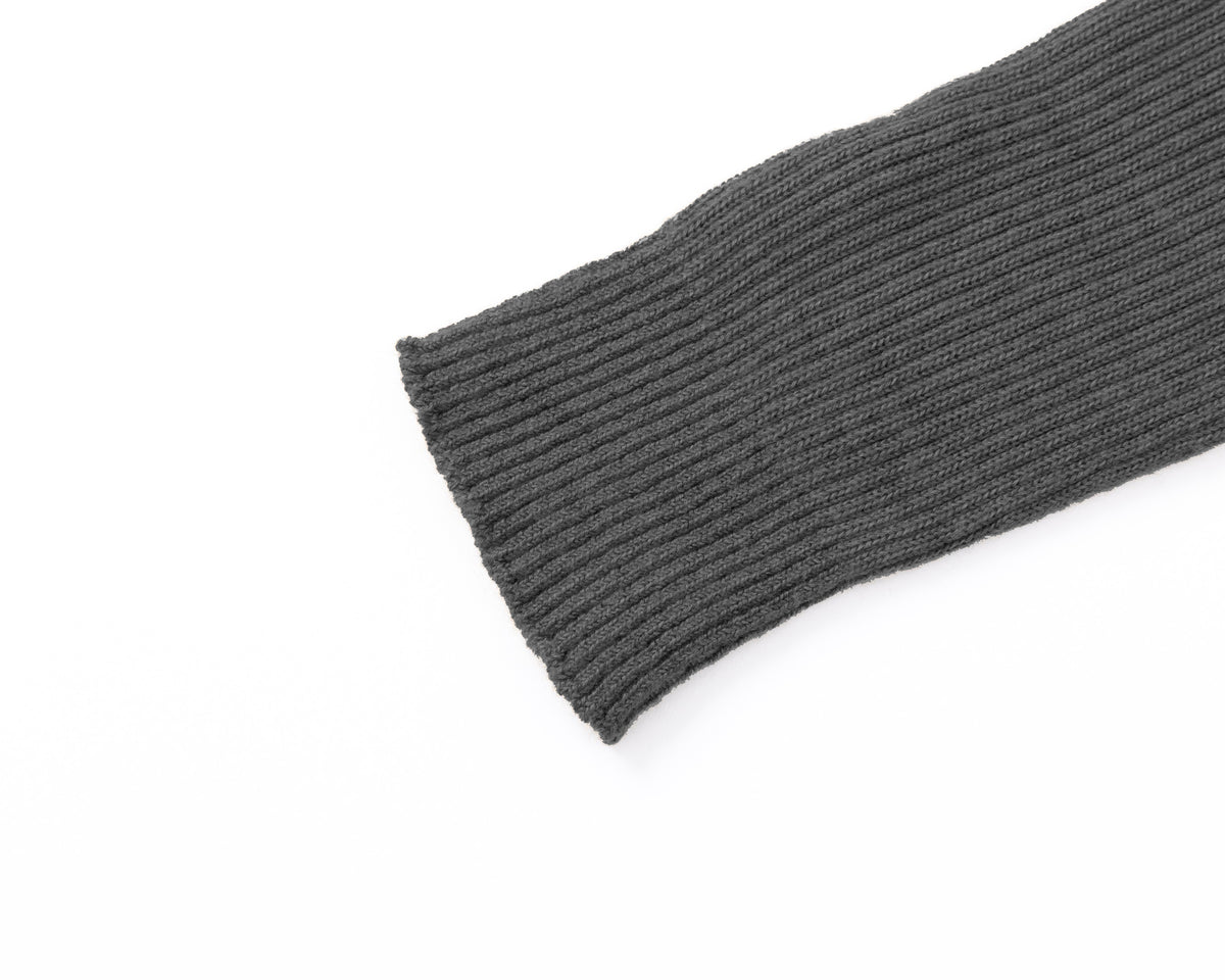 Close-up of a grey ribbed knit sleeve or cuff on a plain white background.