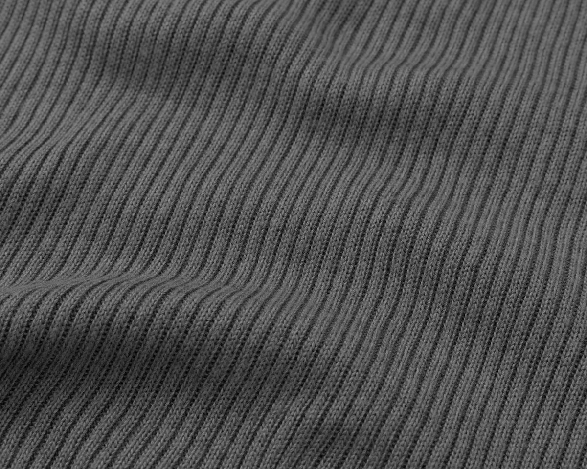 Close-up of a grey ribbed knit fabric texture with vertical ridges and soft folds.