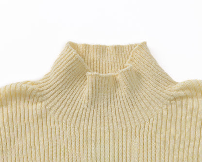 Close-up of a ribbed knit turtleneck sweater in a pale yellow colour, showing the texture and collar detail against a plain white background.