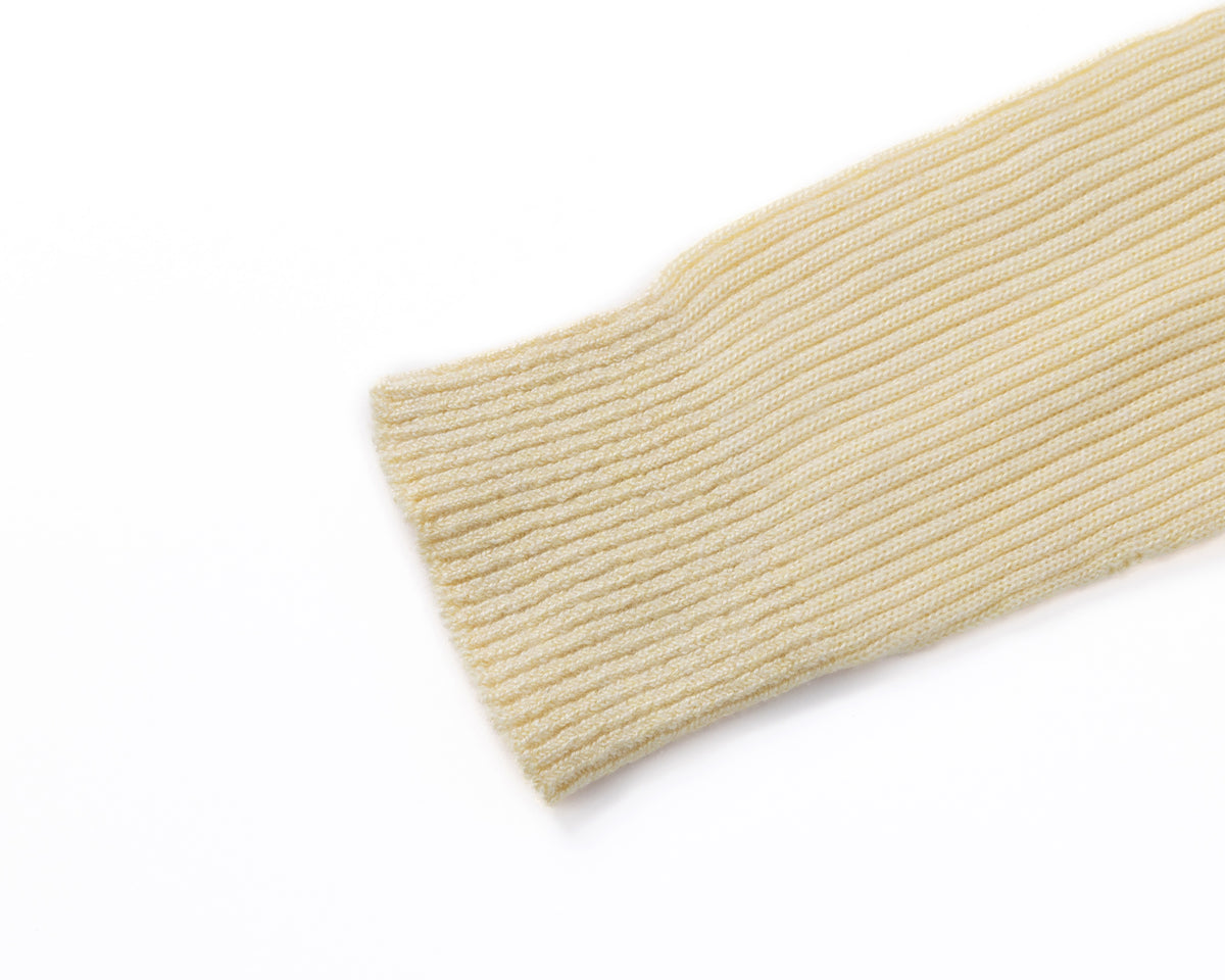 A close-up of a ribbed knit sleeve cuff in a pale yellow colour, shown against a plain white background.