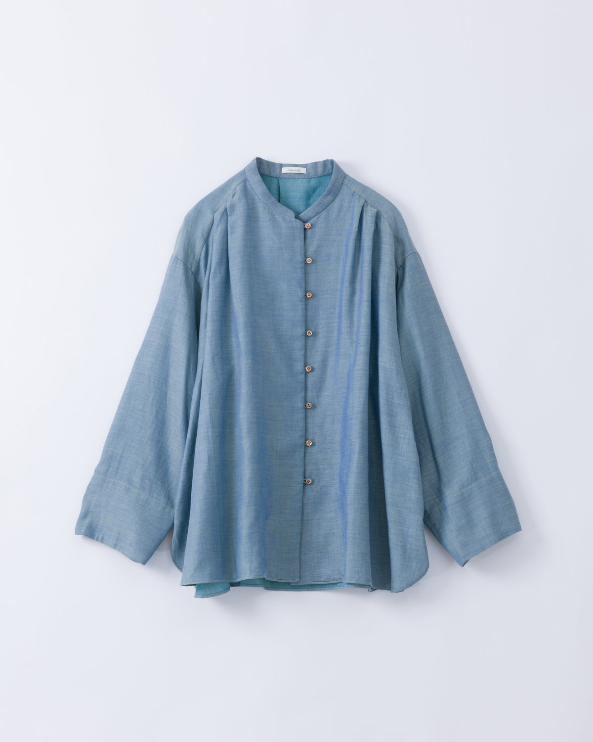 A light blue long-sleeve button-up shirt with a stand collar, laid flat against a light grey background.