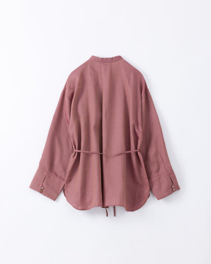 Back side of a pink cotton blouse with a belt on a light grey background