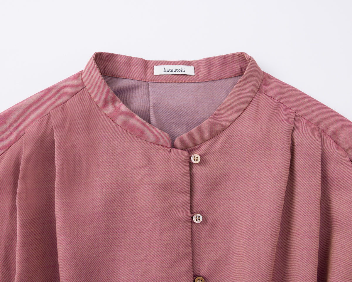 Close-up of a pink cotton shirt with buttons on a white background