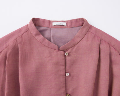 Close-up of a pink cotton shirt with buttons on a white background