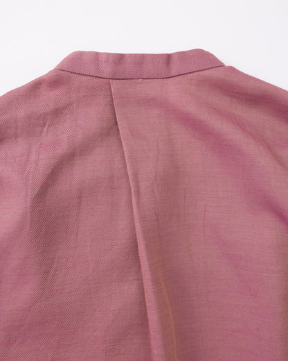Close-up of a pink textured fabric with a collar on a white background