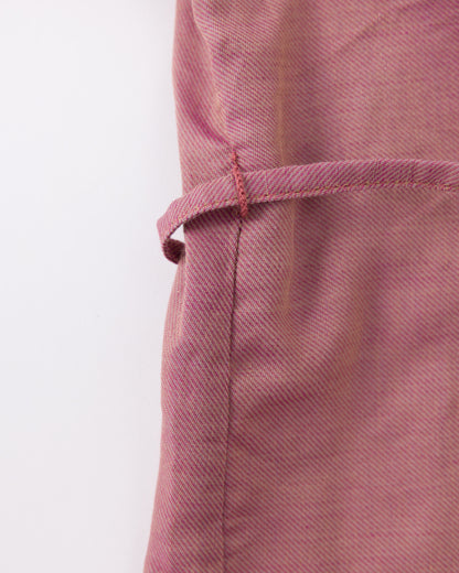 Close-up of a pink fabric with a visible seam on a white background