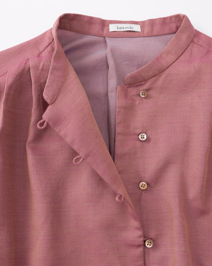 Close-up of a pink shirt with a brand label on a white background