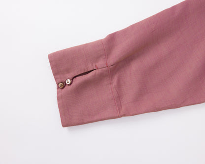 Close-up of a pink shirt cuff with two buttons on a white background