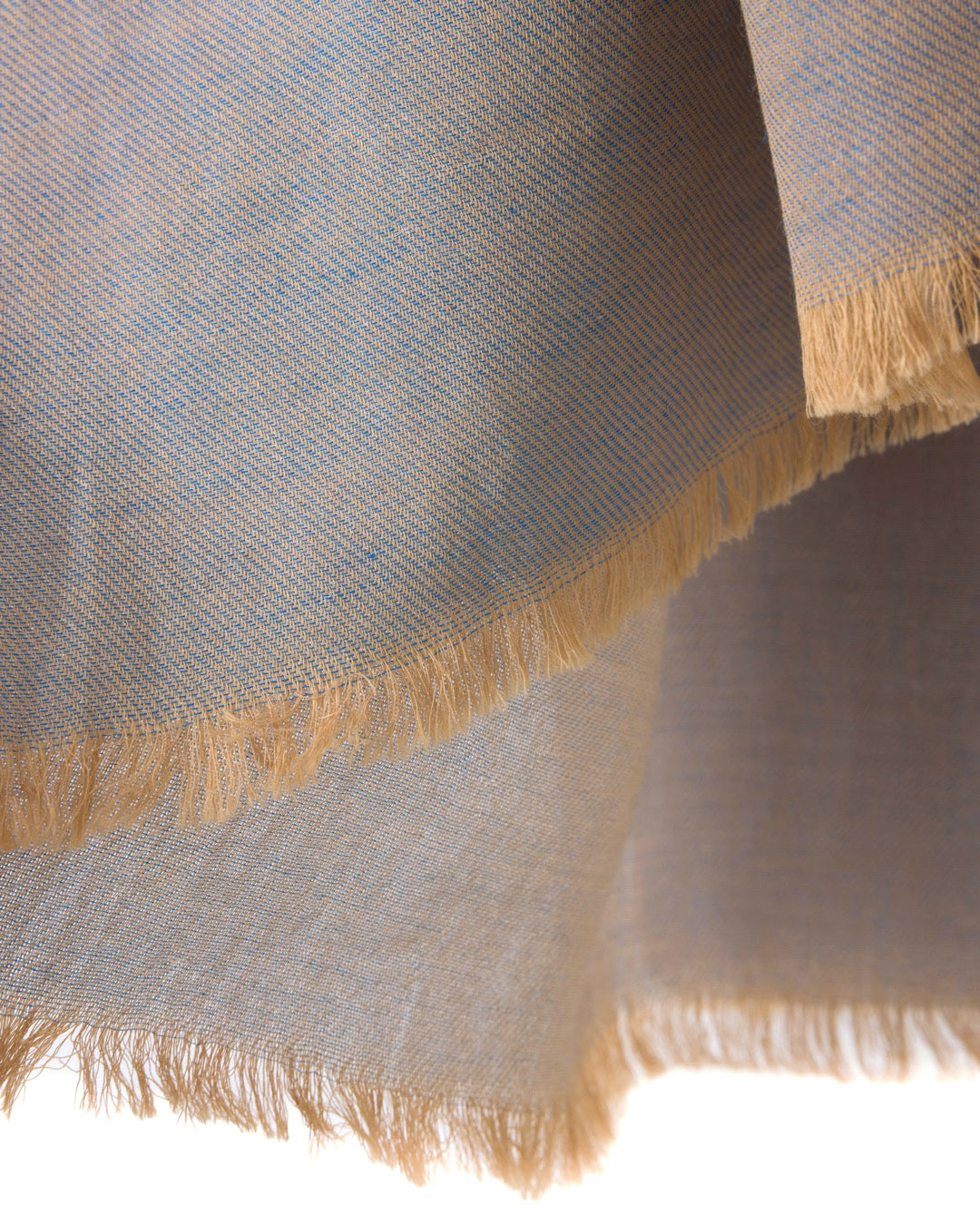 Detail of a grey scarf with blue accents and gold trims on a white background