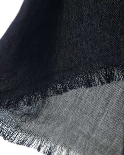 Detail of a navy scarf with trims on a white background