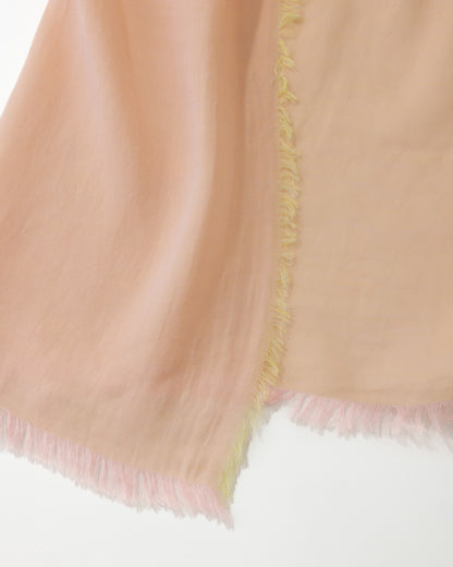 Detail of an orange scarf with pink and yellow trims on a white background