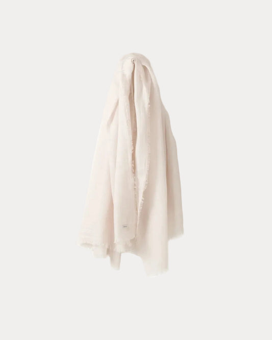 A soft, white-coloured fringed scarf draped against a solid, very light grey background.