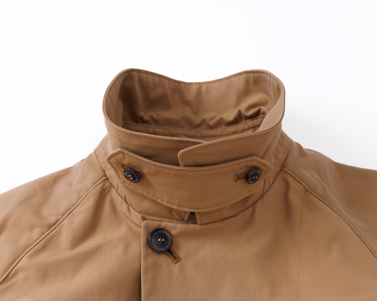 Close-up of a brown car coat with a collar on a white background