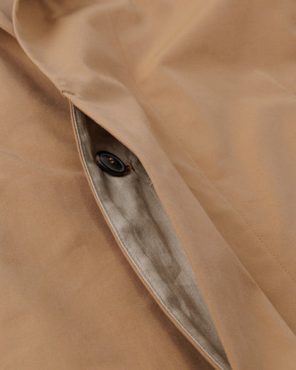 Close-up of a beige fabric with a button, showing texture and color.