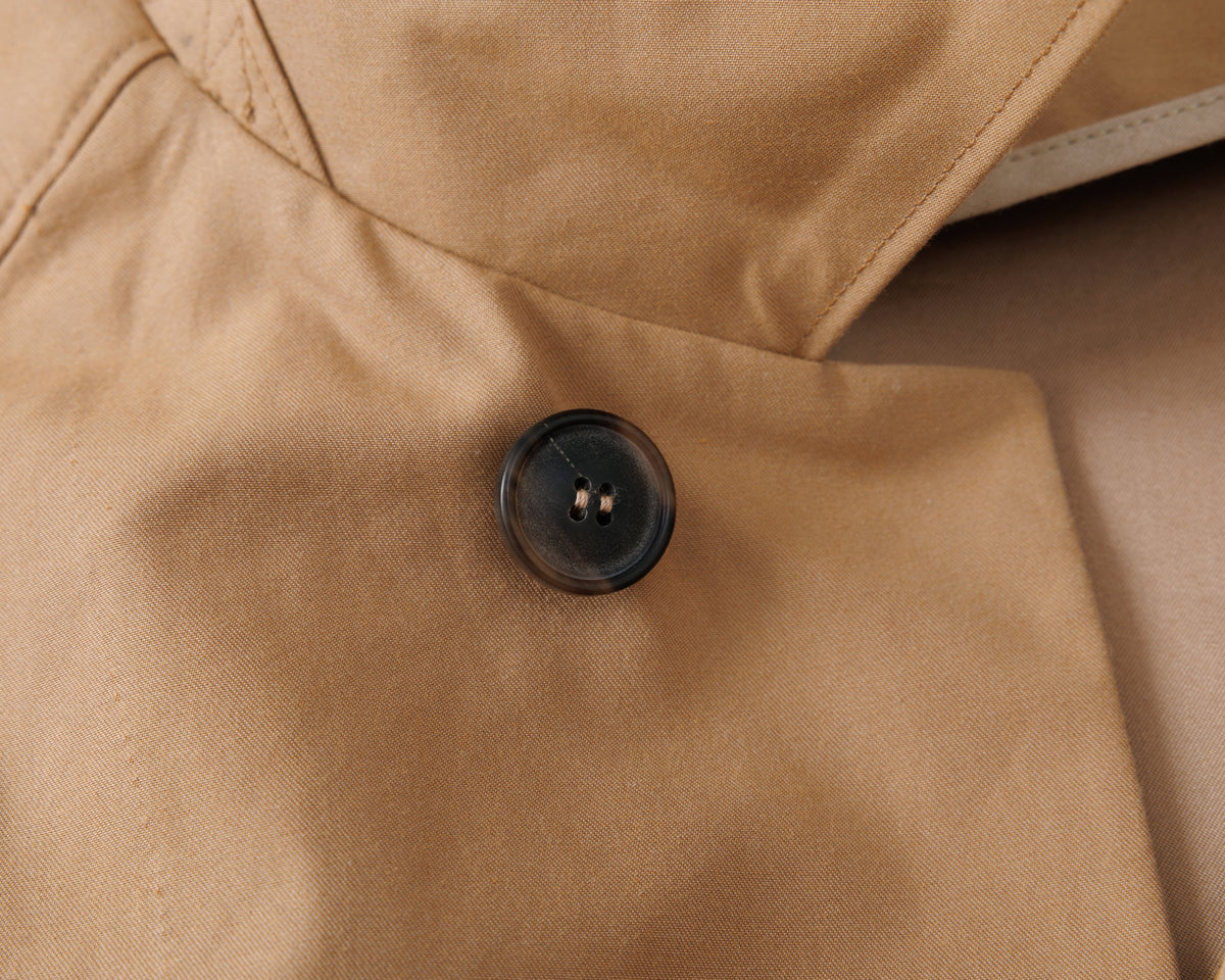 Close-up of a button on a beige fabric surface